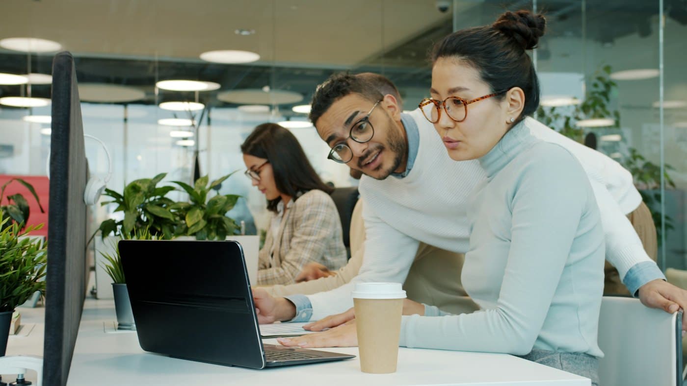 Two colleagues collaborating on a laptop